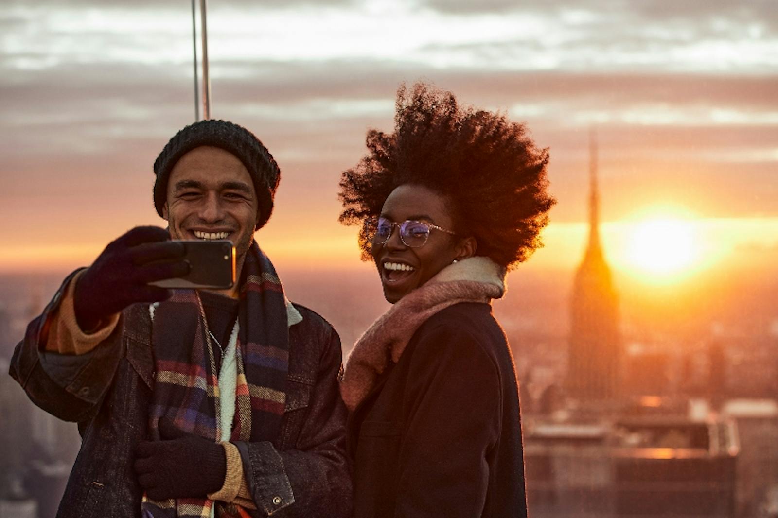 Coppia sorridente che fa selfie al tramonto all'Edge NYC